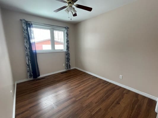 Empty room with wooden floor and window.
