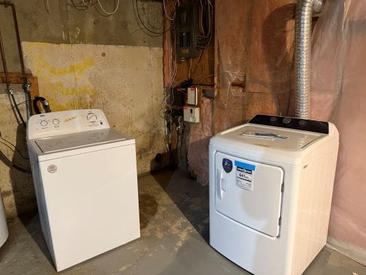 Washing machine and dryer in basement laundry.