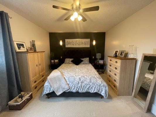 Cozy bedroom with bed and wooden furniture.