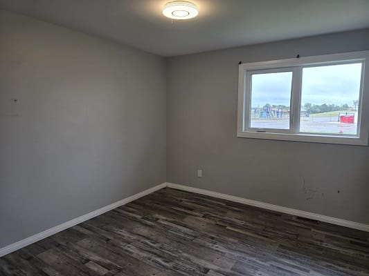 Empty room with wooden floor and window.