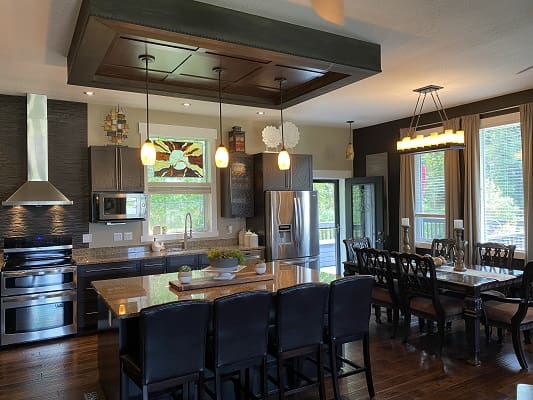 Modern kitchen and dining area with lighting.