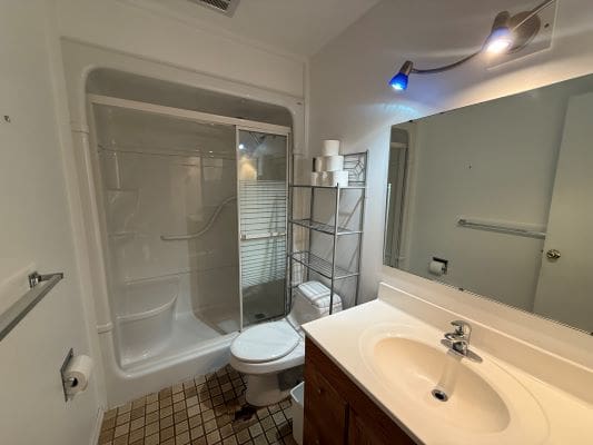 Small bathroom with shower and vanity sink.