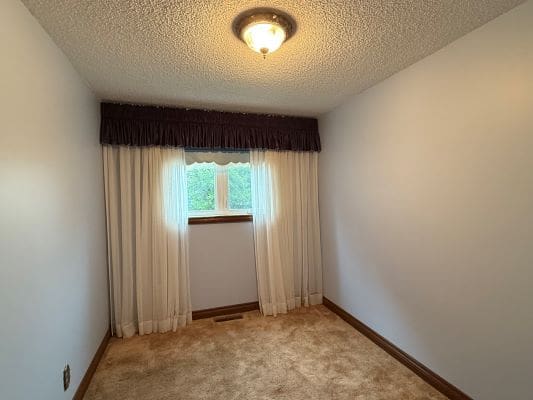 Small room with window and curtains.