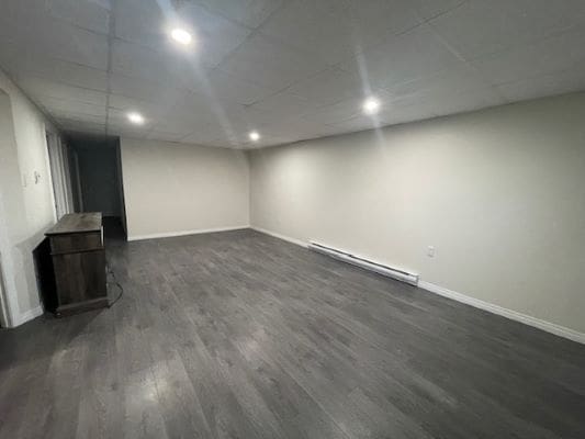 Empty room with dark wood flooring.