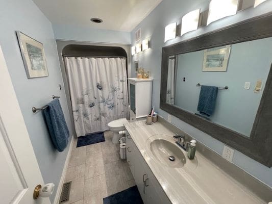 Modern bathroom with blue accents and lighting.