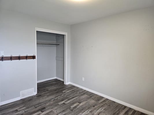 Empty room with a wooden floor and closet.