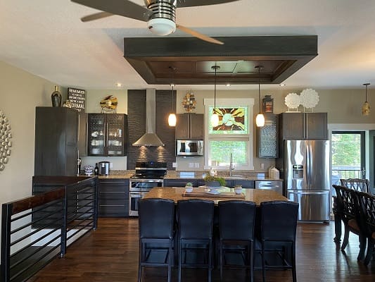 Modern kitchen with island and dark cabinets.