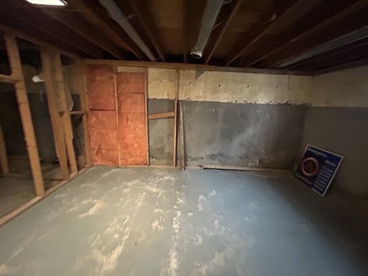 Unfinished basement with exposed wooden beams.