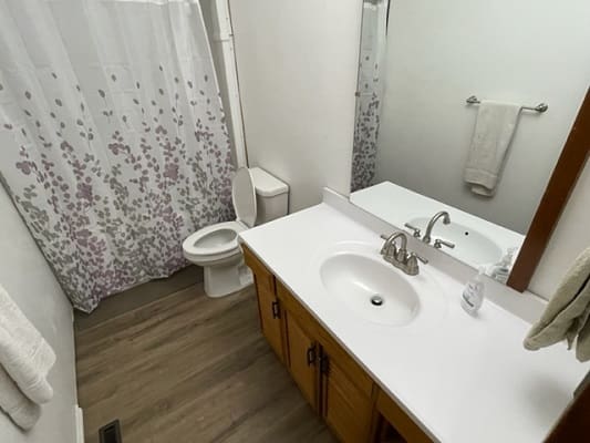 Small bathroom with sink and shower curtain.