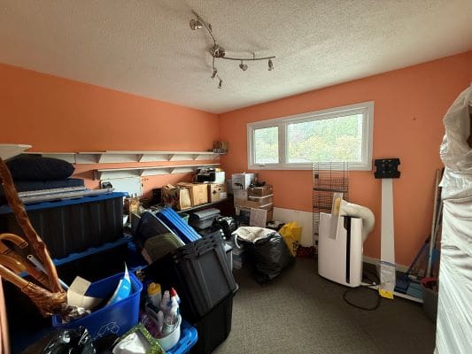 Cluttered room with storage boxes and shelves.