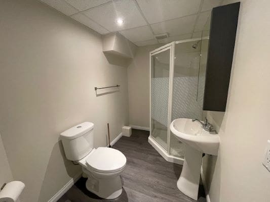 Small bathroom with shower and pedestal sink.