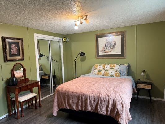 Cozy bedroom with green walls and decor.