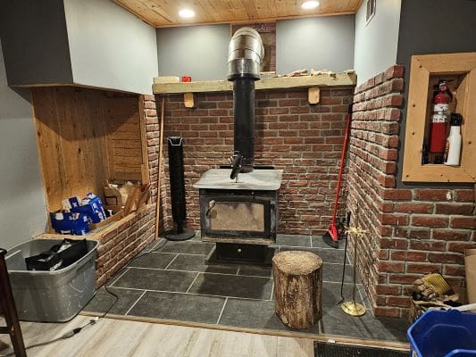 Wood stove in a brick alcove.