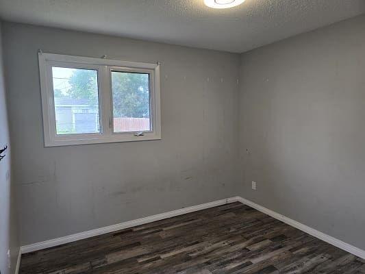 Empty room with wooden floor and window.