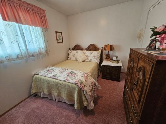 Cozy bedroom with floral decor and furniture.