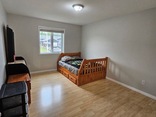 Minimalist bedroom with wooden bed frame.