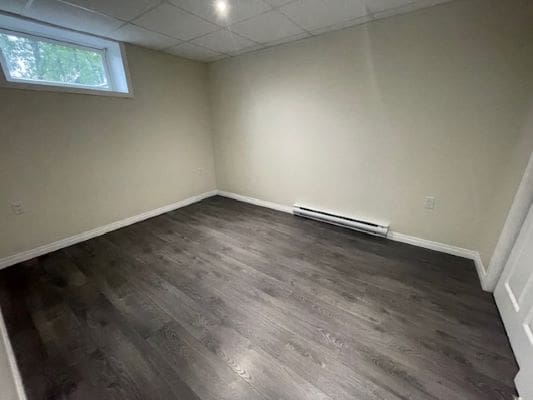 Empty room with dark wood flooring.