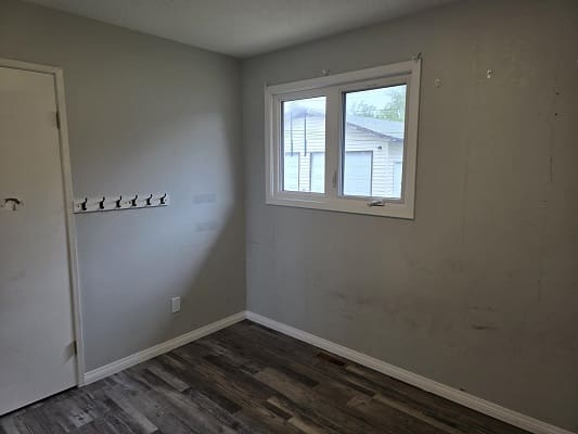 Empty room with window and coat hooks.
