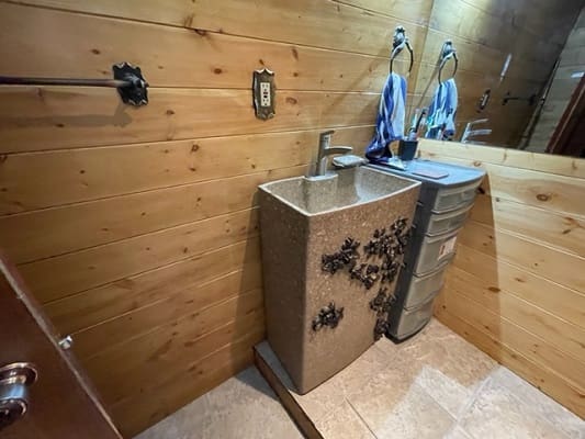 Rustic bathroom with wooden walls and sink.