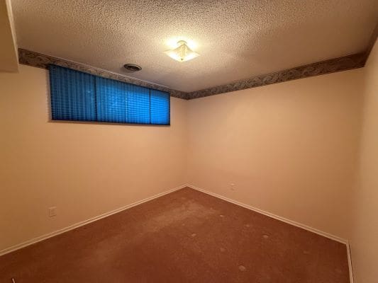 Empty room with carpet and blue blinds.