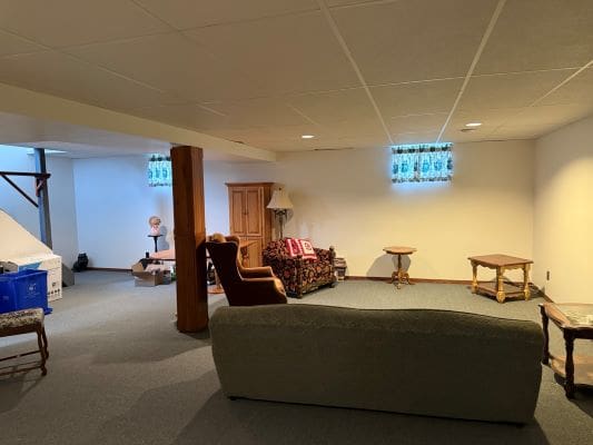 Basement with furniture and small windows.