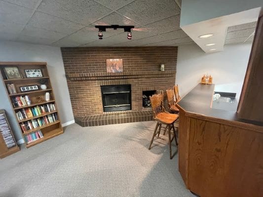 Basement room with fireplace and bar.