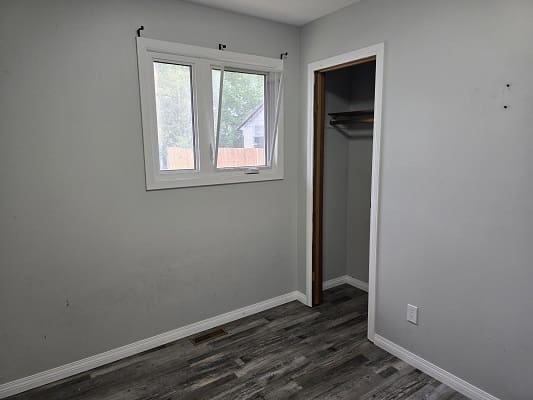 Empty room with window and closet.