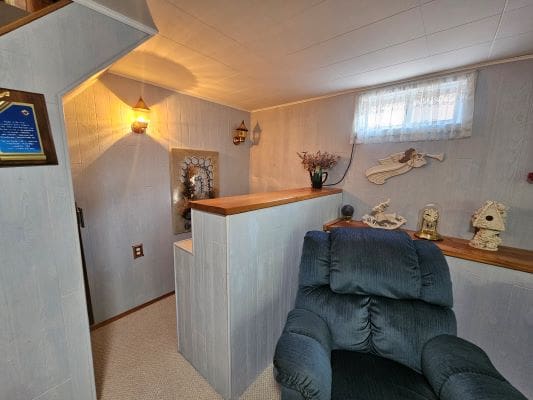 Cozy basement corner with armchair and decor.