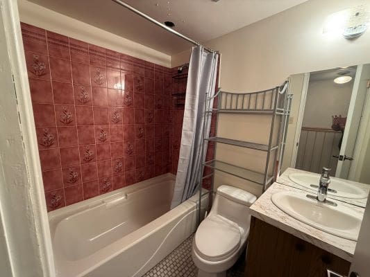 Bathroom with red tiles and white fixtures.