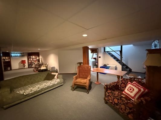 Basement with furniture and bookshelves, cozy setting.