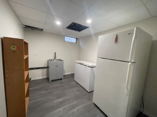 Basement laundry room with appliances and shelving.