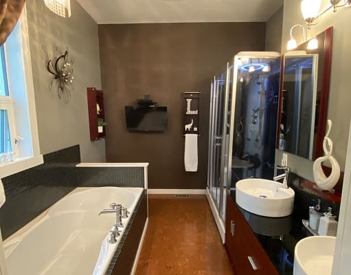 Modern bathroom with bathtub and shower enclosure.