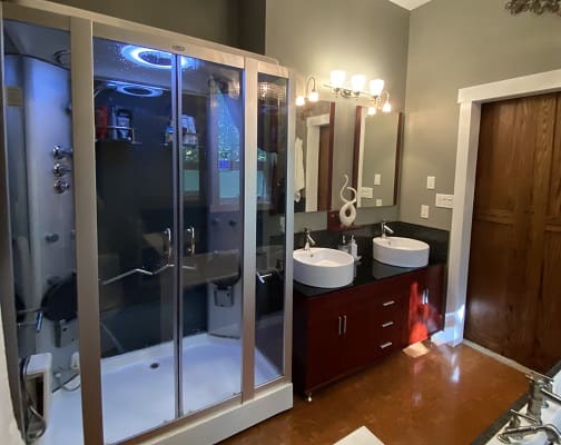 Modern bathroom with dual sinks and shower.