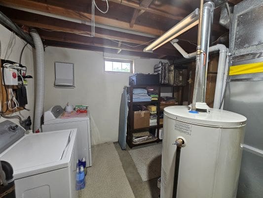 Basement laundry room with water heater, shelves.