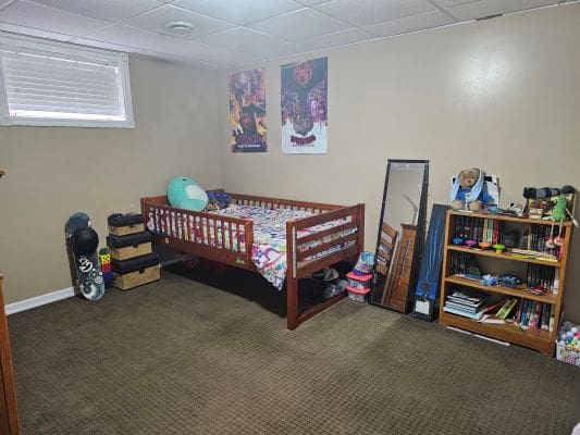 Child's bedroom with bed and bookshelf.