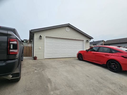 Garage with red and black cars parked.
