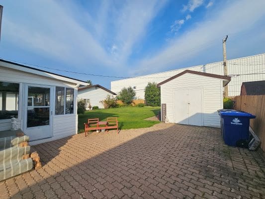 Backyard with patio and storage shed.