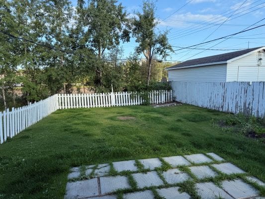 Green yard with white picket fence.