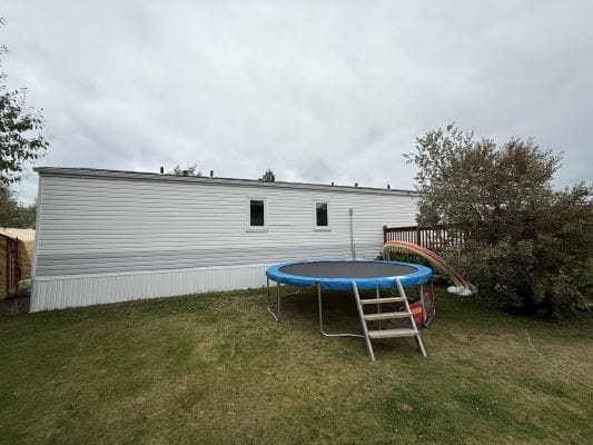 Mobile home with trampoline and garden.