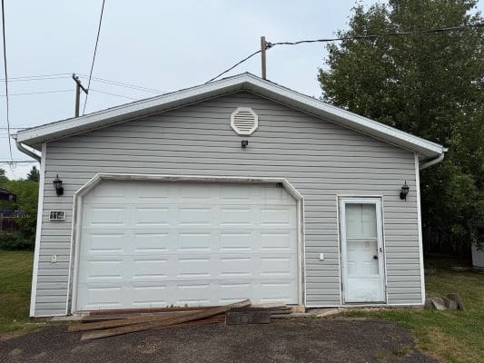 Gray garage with white door and siding.