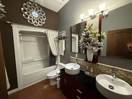 Modern bathroom with double sinks and decor.