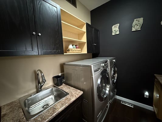 Modern laundry room with washer and sink.