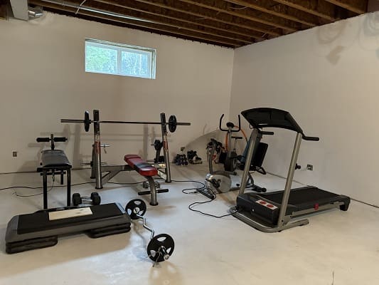 Home gym with treadmill and weight bench.