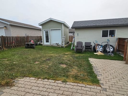 Backyard with sheds and patio chairs.