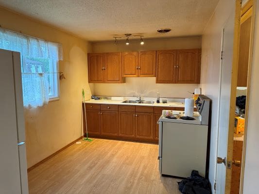 Simple kitchen with wooden cabinets and appliances.