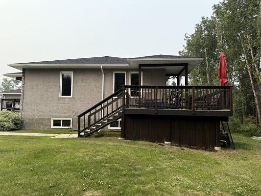 House with wooden deck and red umbrella.