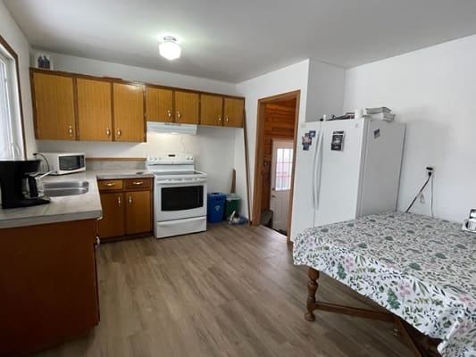 Simple kitchen with wooden cabinets and appliances.