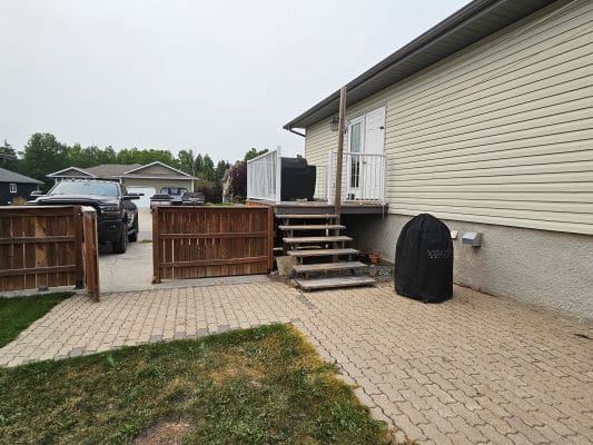House patio with stairs and covered grill.
