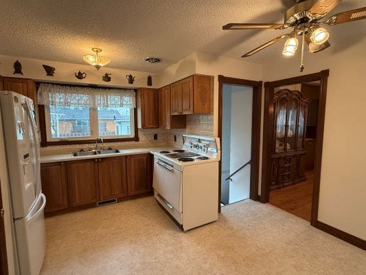Vintage kitchen with wooden cabinets and appliances.
