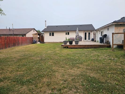 Backyard with deck and grassy lawn.